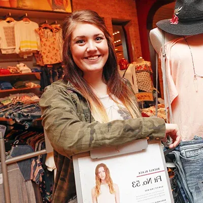 an intern poses for a photo in a store